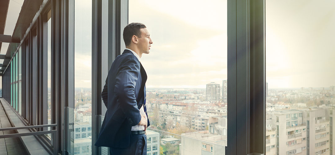 blog-featured-2020_economic_outlook-1080x500 Man looking outside window