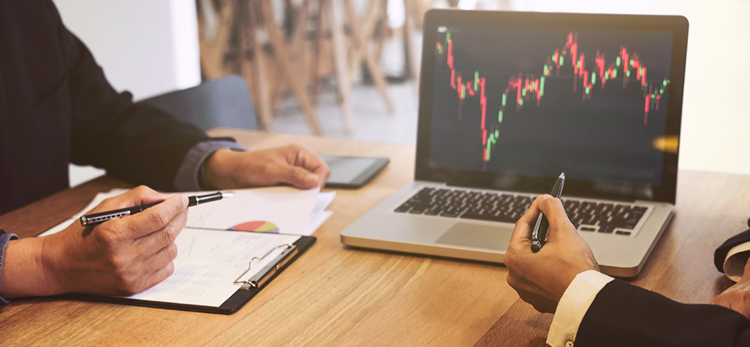 blog-featured_wealth-market-perspectives-2019-q2_1080x500 Two men at a desk look at a graph on a laptop.