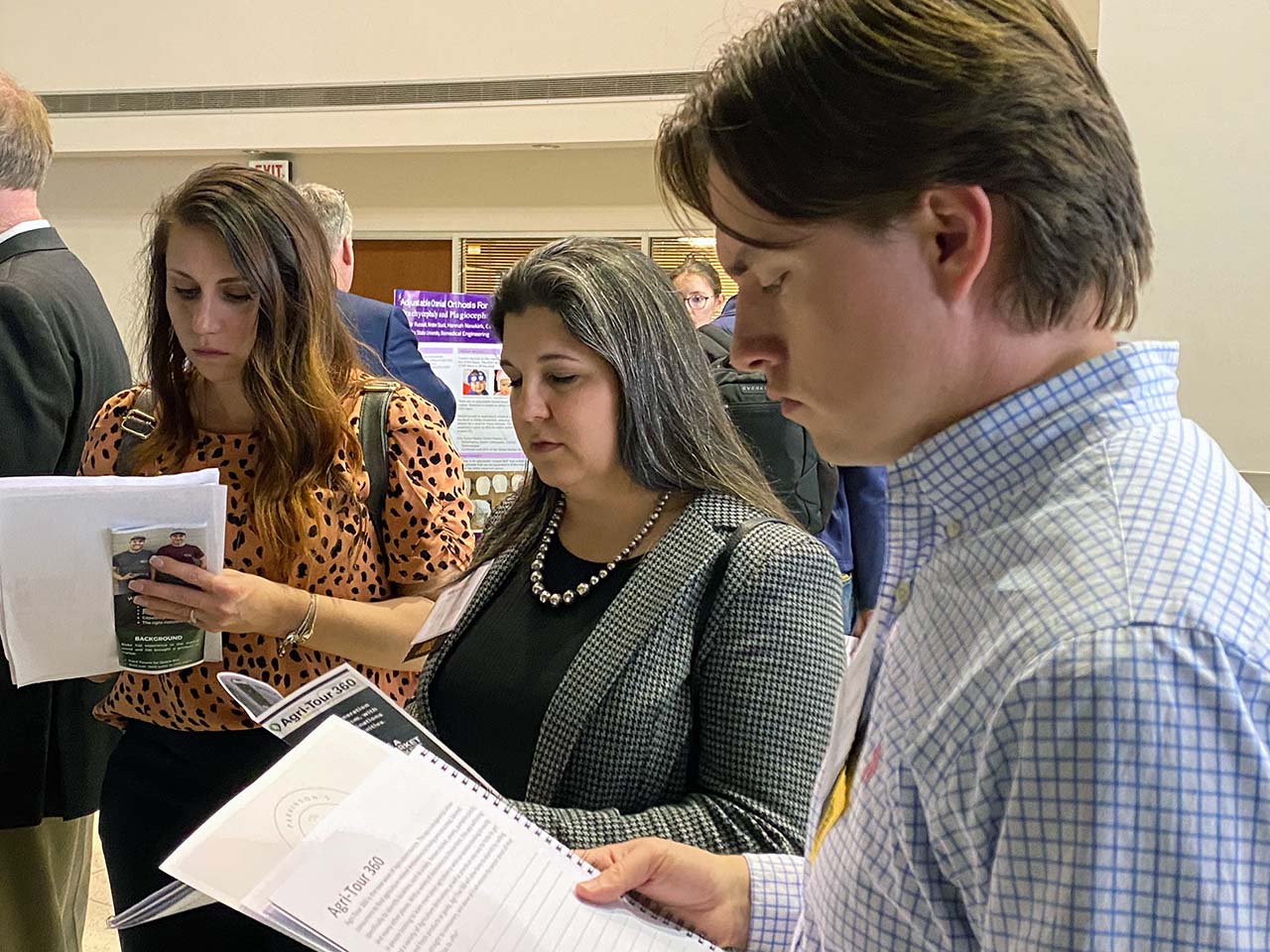 From left: Shumard, Baker, and Durano read about the Agri-Tour 360 app. 