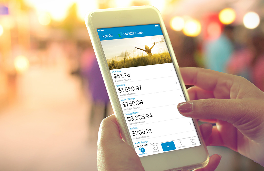 photo-mobile_banking_iphone_outdoors-1080x700 Hands holding an iPhone with INTRUST Mobile Banking