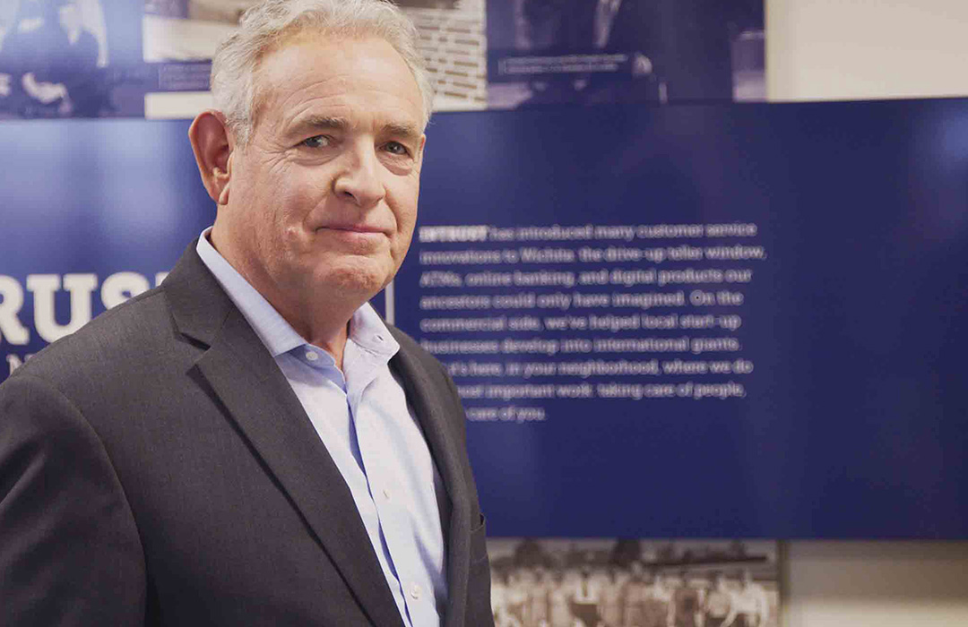 photo-stan_business-1080x700 A man looking in to the camera standing in a banking center