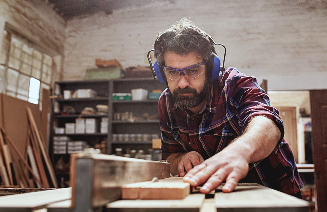 photo-woodshop_small_business_man-1080x700 A man works in a woodshop with a saw